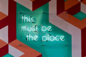 a neon sign on a wall. this must be the place. Digital Marketing, Strategy, Paid Media. Ana Isabel Moura.